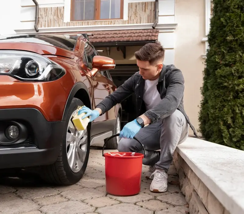 Lavage auto à domicile Les Coteaux Périgourdins : professionnel intervenant sur un véhicule